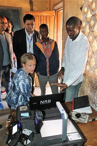 UNDP Malawi A group of people standing around a desk, looking at a computer screen