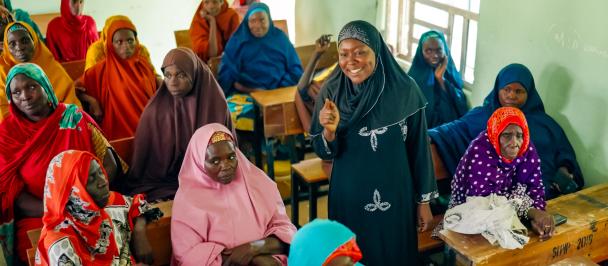 Falmata Alhaji Modu speaking to a group of women in colourful attire